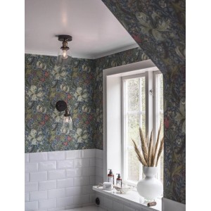 PR Home Lambda Wandleuchte im Badezimmer mit floraler Tapete und weißen Fliesen.