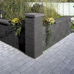 Anthrazit Gartenmauer aus Betonsteinen mit Bepflanzung als Grundstückseinfassung.