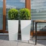 Zwei weiße Siena Garden Pflanzsäulen Nizza 35x35x68 cm mit Rillenoptik und Bepflanzung.