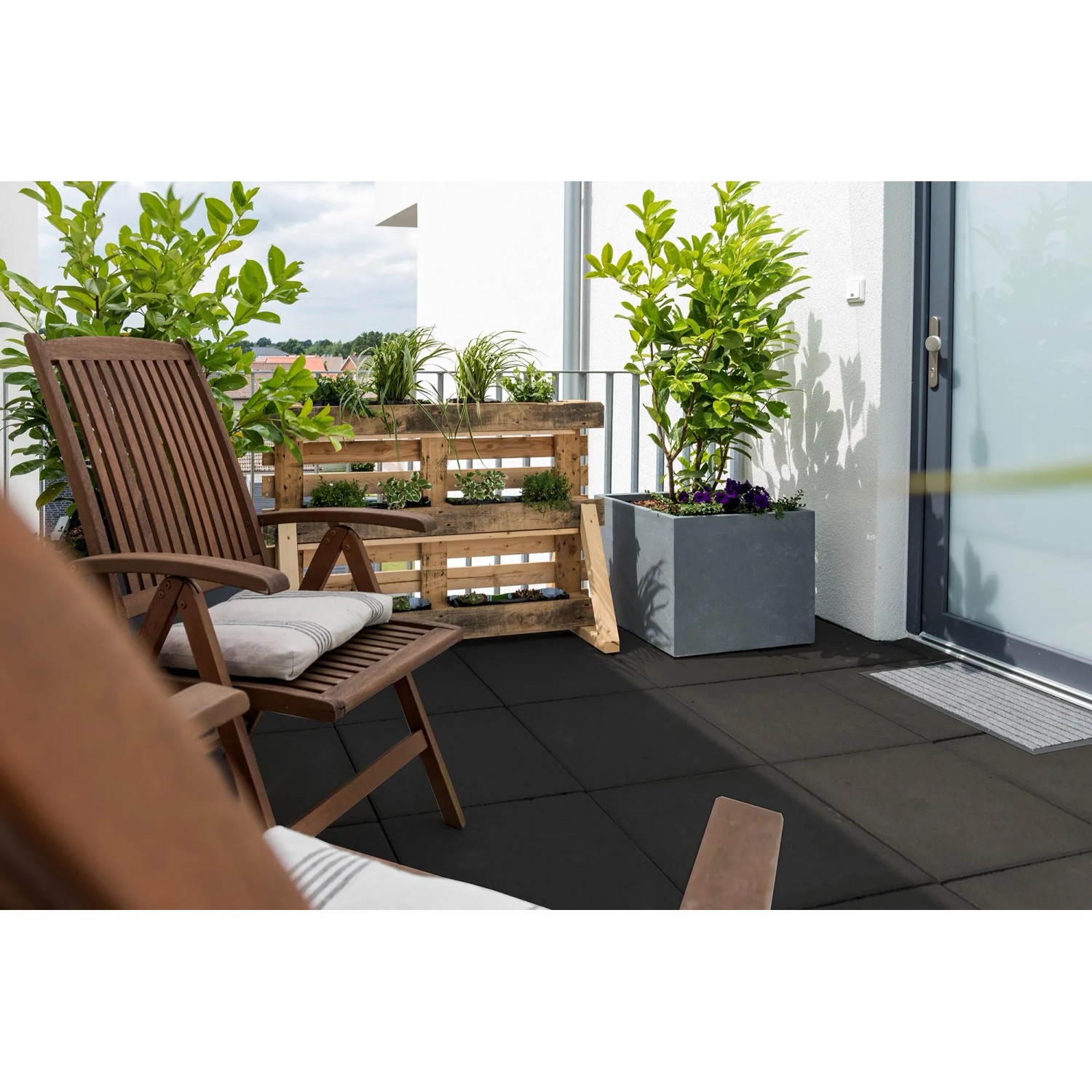 Diephaus Gehwegplatte Anthrazit 50x50 cm auf Balkon mit Gartenmöbeln und Pflanzen.