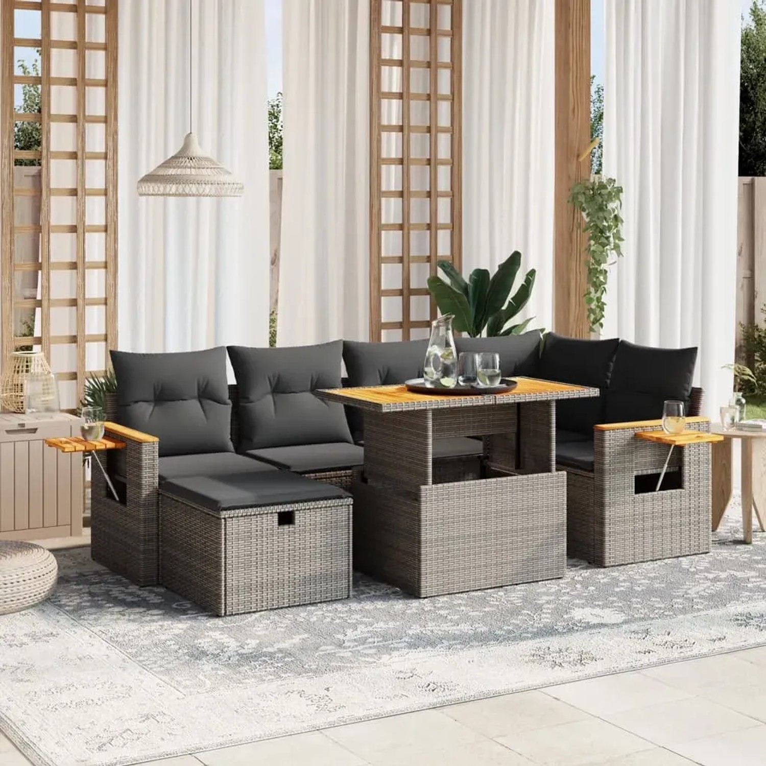 7-teilige graue Garten-Sofagarnitur aus Polyrattan mit Tisch, Hockern und Kissen.