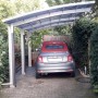 Ximax Carport Portoforte-110 im Edelstahl-Look mit Auto. Einzelcarport mit transparentem Dach.