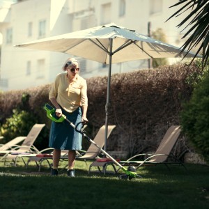 Frau trimmt Rasen mit Greenworks Akku-Rasentrimmer G40LTK2. Inkl. Akku und Ladegerät.