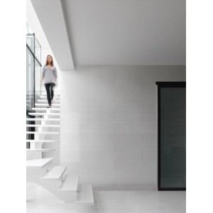 Heller Raum mit weißer Wandverkleidung aus Grosfillex Paneelen und Treppe.