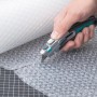 Hand schneidet Luftpolsterfolie mit wolfcraft Profi-Dual-Sicherheitsmesser. Messer mit Trapezklinge.