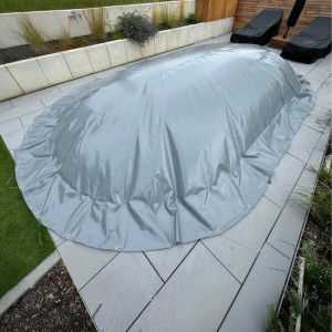 Graue Luftkissen Poolabdeckung für Oval-/Achtformpools, 600x320 cm, mit Ösen und Spannseil.