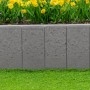 Graues EHL Rechteck-Palibord Tulo als Beeteinfassung mit gelben Blumen.