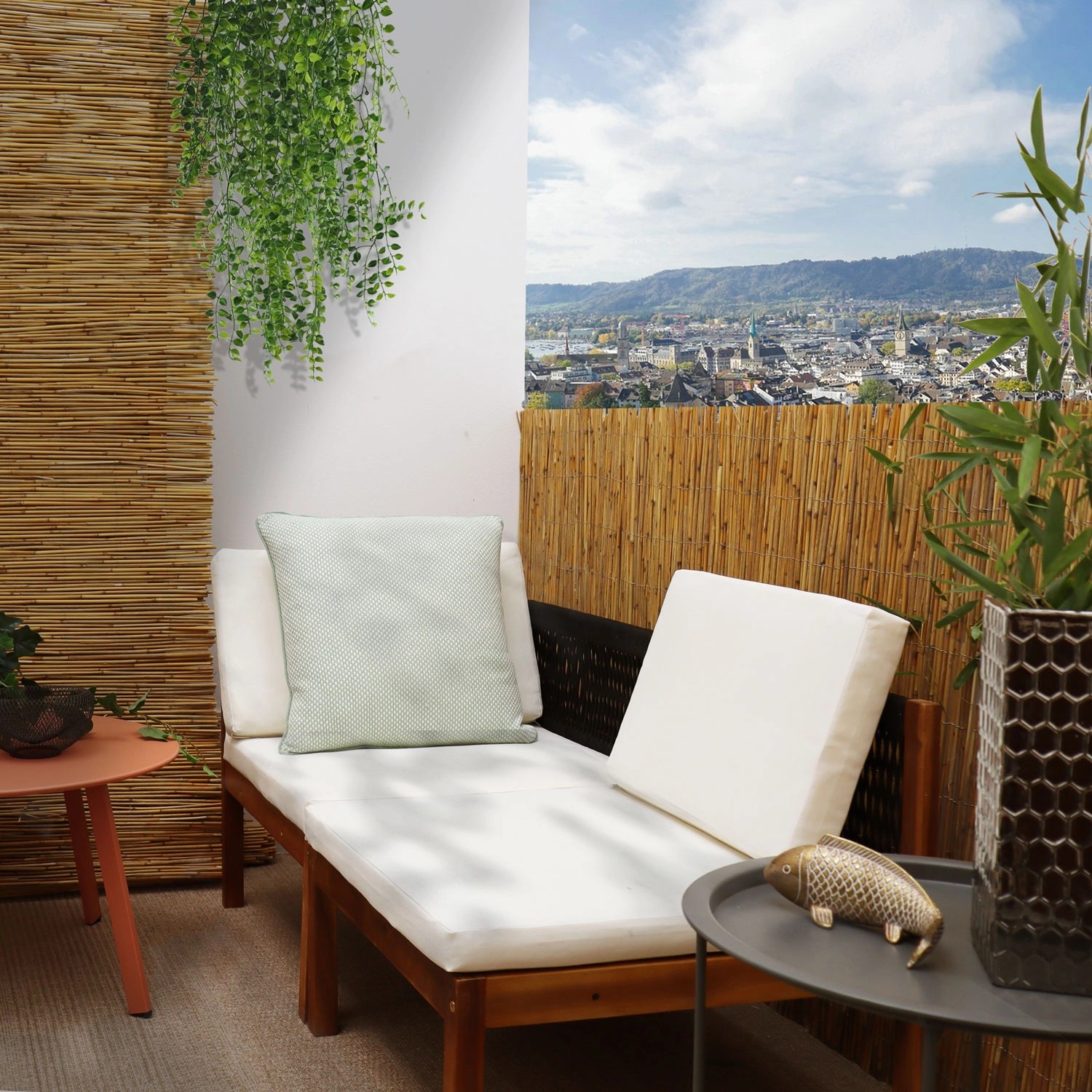 Braune urfence Schilfmatte als Sichtschutz auf einem Balkon mit Liege und Stadtblick.