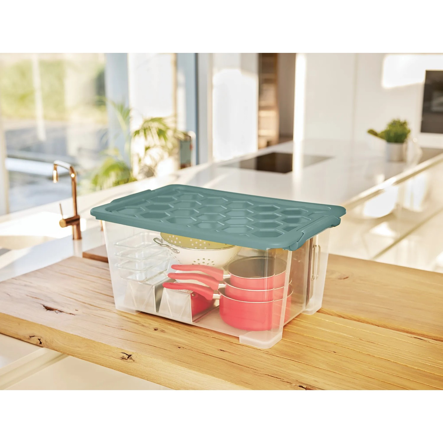 Transparente Rotho Aufbewahrungsbox Evo Safe mit grünem Deckel, gefüllt mit Küchenutensilien.