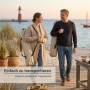 Paar trägt beige osoltus Faltsessel in Tragetaschen am Strand. Einfach zu transportierender Campingstuhl mit Aluminiumgestell.
