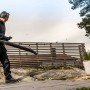 Mann mit 3M Peltor Gehörschutz beim Laubblasen im Garten.