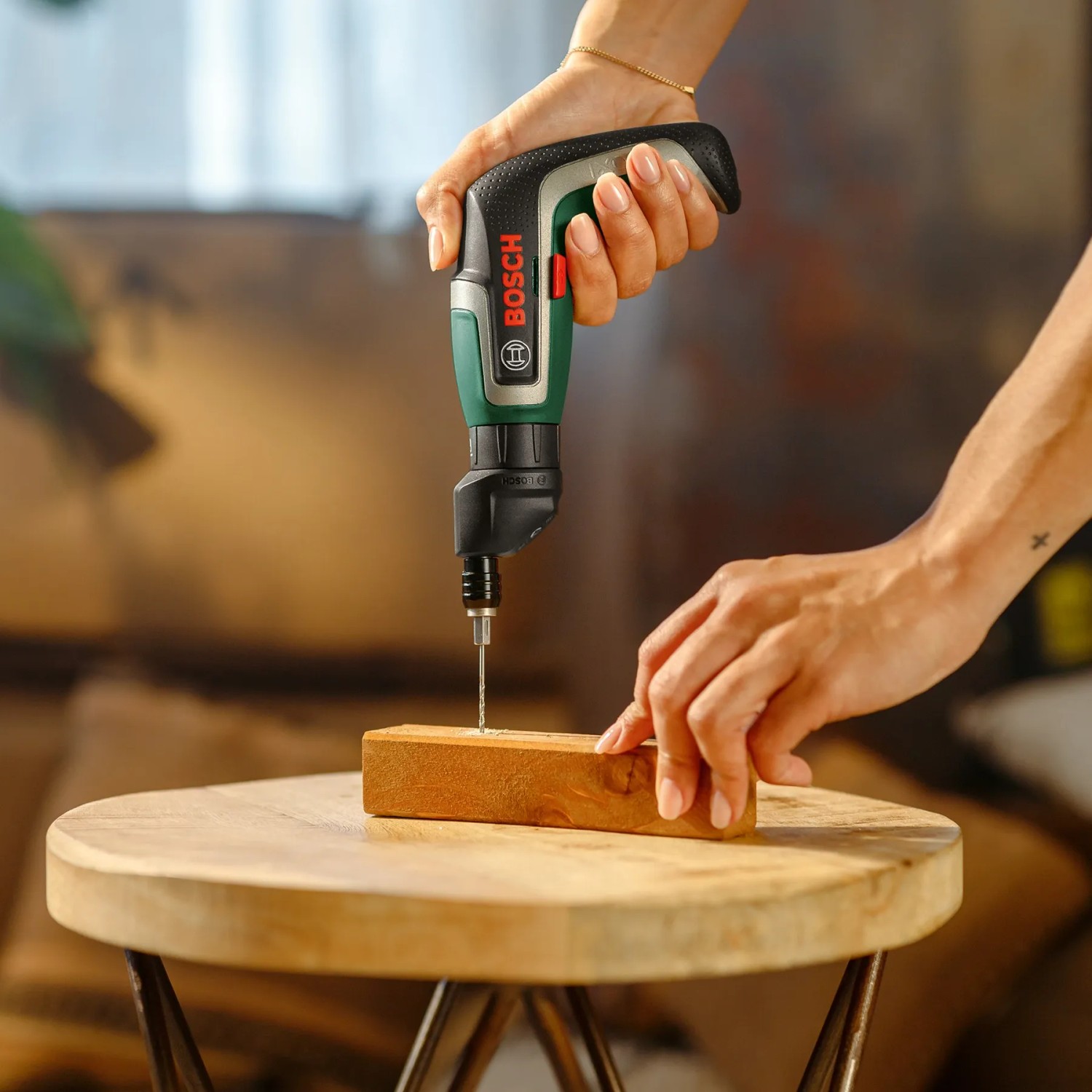 Bosch IXO 7 Akkuschrauber beim Schrauben in Holz. Kompaktes Design, ideal für kleine Schraubarbeiten.