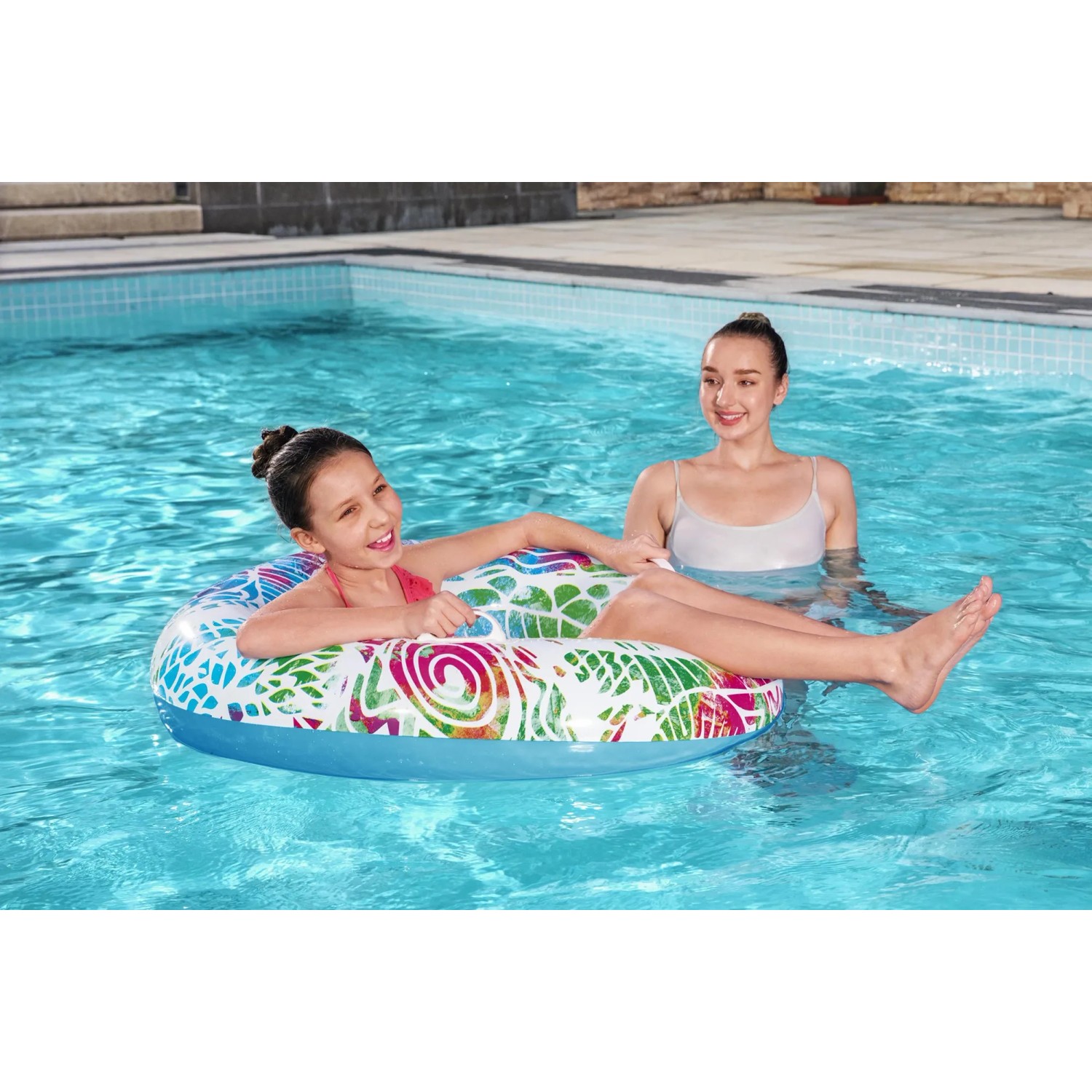 Bestway Schwimmring Summer Swirl mit Mandala-Design im Pool, genutzt von Kind und Erwachsener.