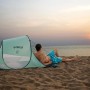 Pavillo Strandmuschel Beach Quick 2 mit Mann am Strand im Sonnenuntergang.