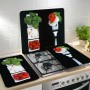 Wenko Herdabdeckplatten Caprese 2er Set auf einem Herd, mit Tomaten, Mozzarella und Basilikum Motiven.