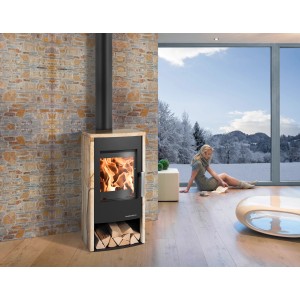 Haas+Sohn Kaminofen Rubus mit Natursteinverkleidung, 6 kW, in Wohnraum mit Frau am Fenster.