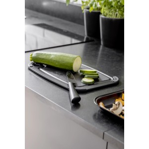 Wenko Gemüsemesser Ace auf Schneidebrett mit Zucchini. Küchenhelfer aus Edelstahl, schwarz.
