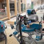Bosch Professional GCM 12 GDL Kapp- und Gehrungssäge mit Kreissägeblatt im Einsatz mit Absaugung.