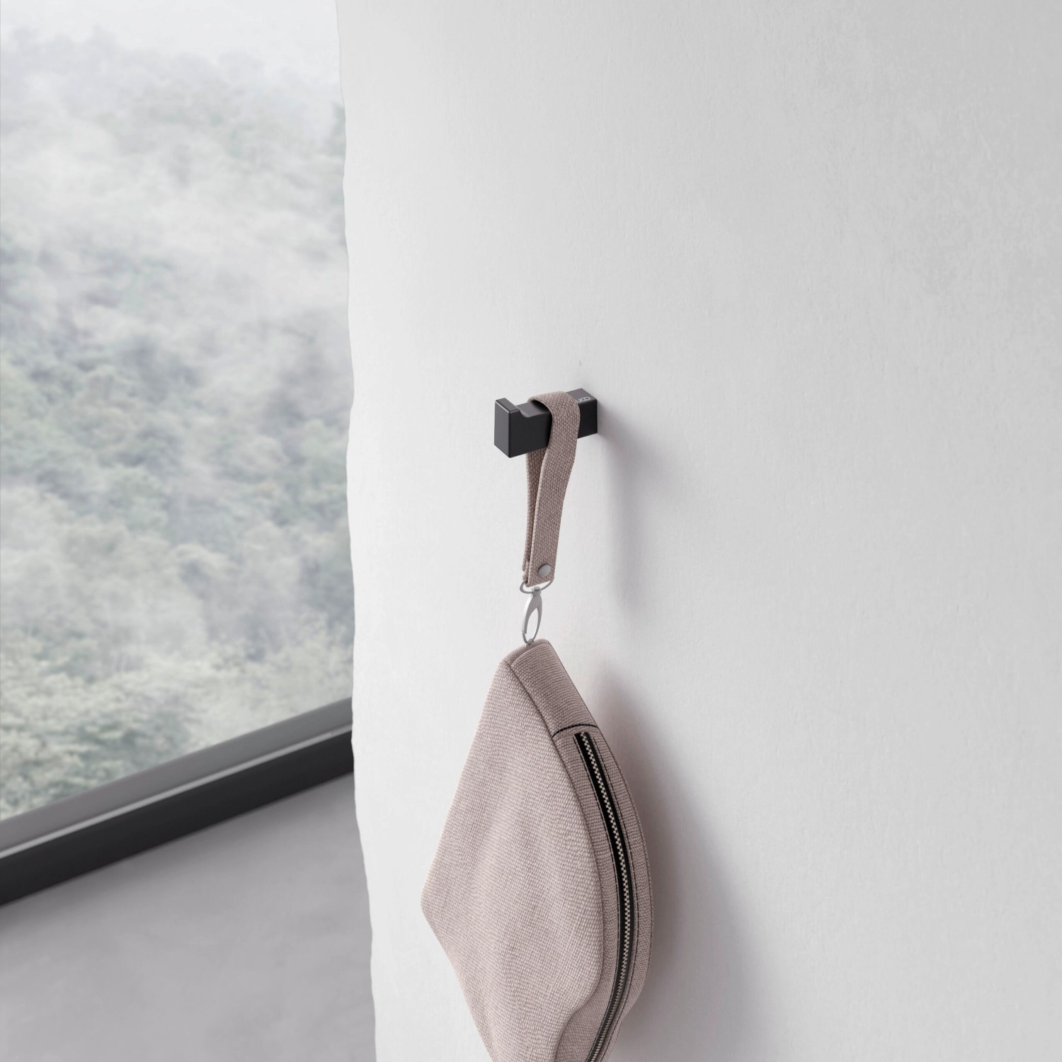 Keuco Handtuchhaken Edition 11 Black Selection, schwarz-matt, mit Handtasche an weißer Wand.