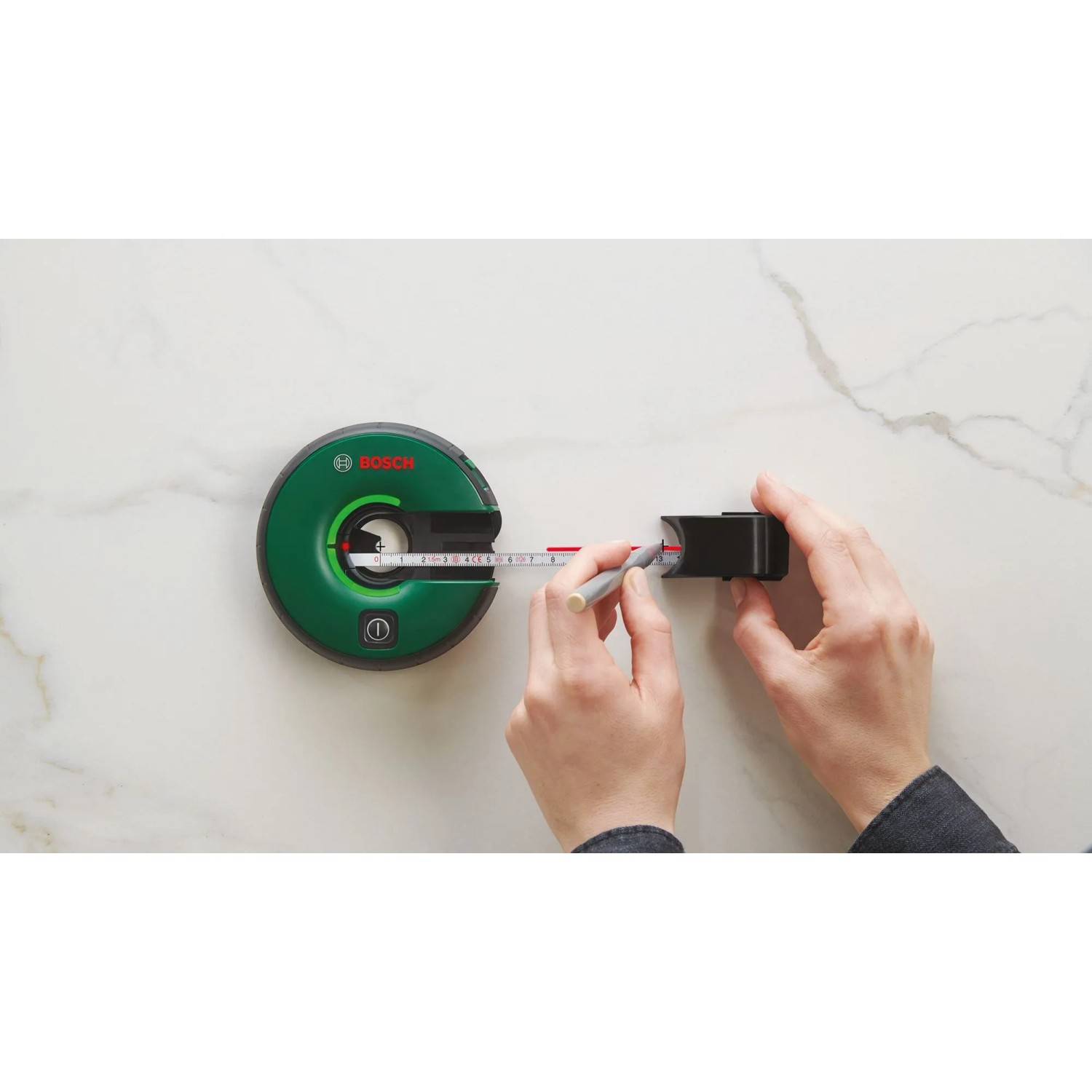 Bosch Atino Linienlaser mit Maßband im Einsatz zum Ausrichten und Messen.