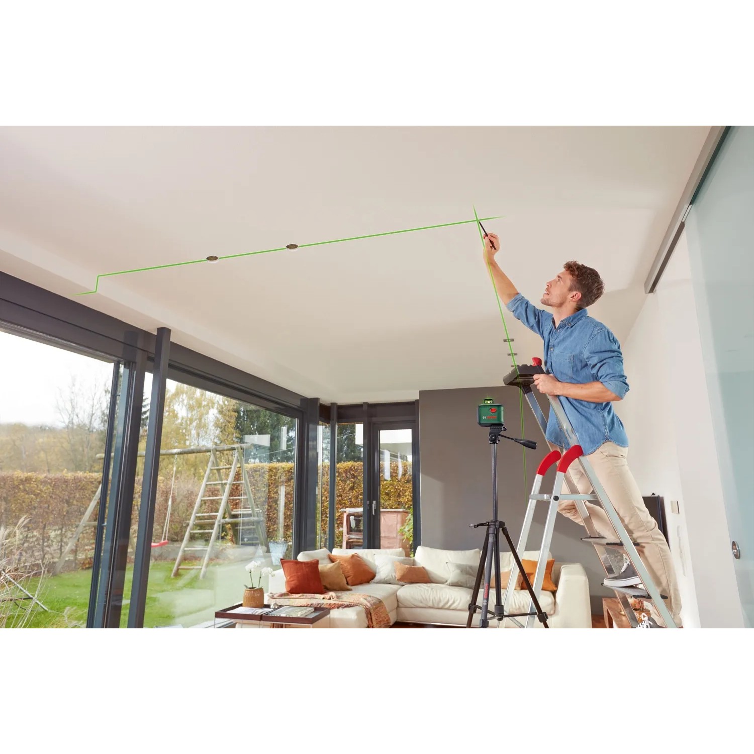 Bosch AdvancedLevel 360 Kreuzlinienlaser im Einsatz: Mann richtet Laserlinien an Zimmerdecke aus.