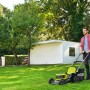 Ryobi Akku-Rasenmäher RY18LMX46A-250 im Einsatz: Mann mäht Rasen mit dem 46 cm Brushless-Mäher.