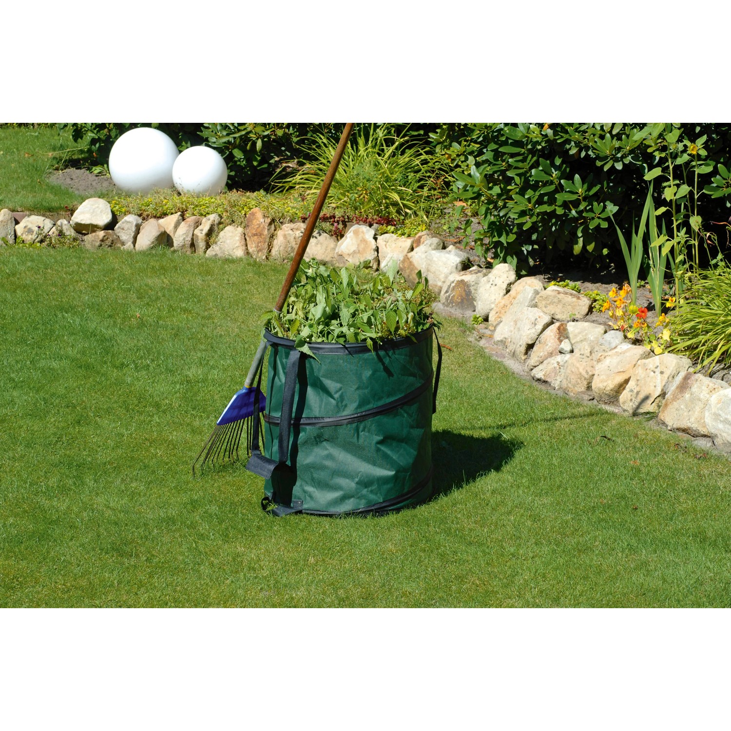 Grüner Gartensack Pop Up 150 l gefüllt mit Gartenabfällen im Garten.