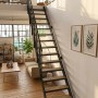 Minka Raumspartreppe Flex Hybrid: schwarze Metalltreppe mit Eichen-Design-Stufen in modernem Wohnraum zur Galerie.