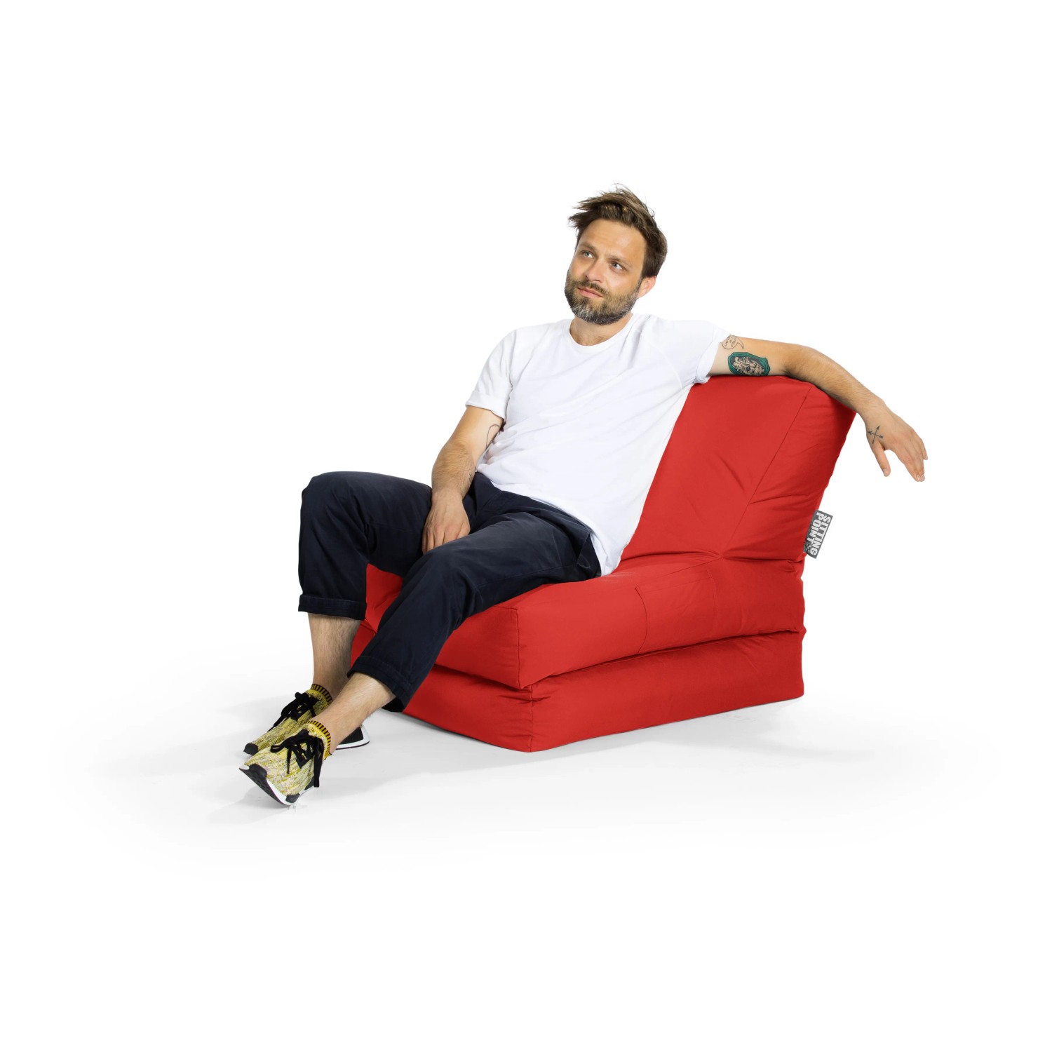 Mann sitzt entspannt im roten Sitting Point Sessel Twist Scuba, einem bequemen Sitzsack für Indoor und Outdoor.