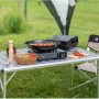Campingaz Camp'Bistro 3 Tischkocher mit Zubehör auf einem Campingtisch im Freien.