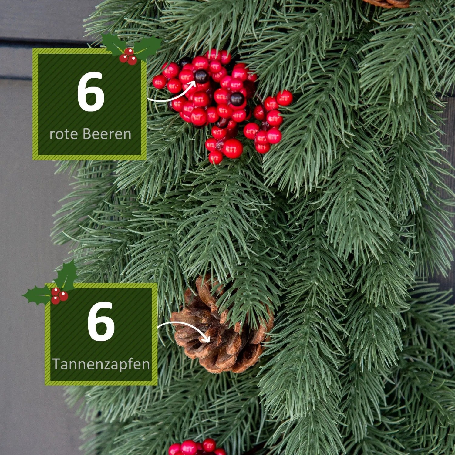 Grüner künstlicher Tannenkranz mit roten Beeren und braunen Tannenzapfen. Detailansicht der Weihnachtsdekoration.