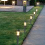 Zehn Marelida LED Solar Wegleuchten aus Edelstahl mit Erdspieß säumen einen Gartenweg. Sie spenden warmweißes Licht und sind 15cm hoch.