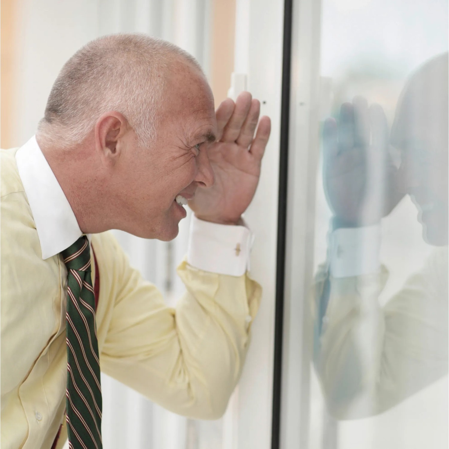 Mann schaut durch Fenster mit Venilia Spiegelfolie, die Privatsphäre bietet.