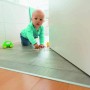 Abus Türstopper JC6200 Luca im Einsatz mit Kind und Spielzeug vor einer Tür.