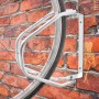 Silberne Metall Fahrradwandhalterung, schwenkbar, an roter Ziegelwand mit eingespanntem Fahrradreifen. Platzsparend.