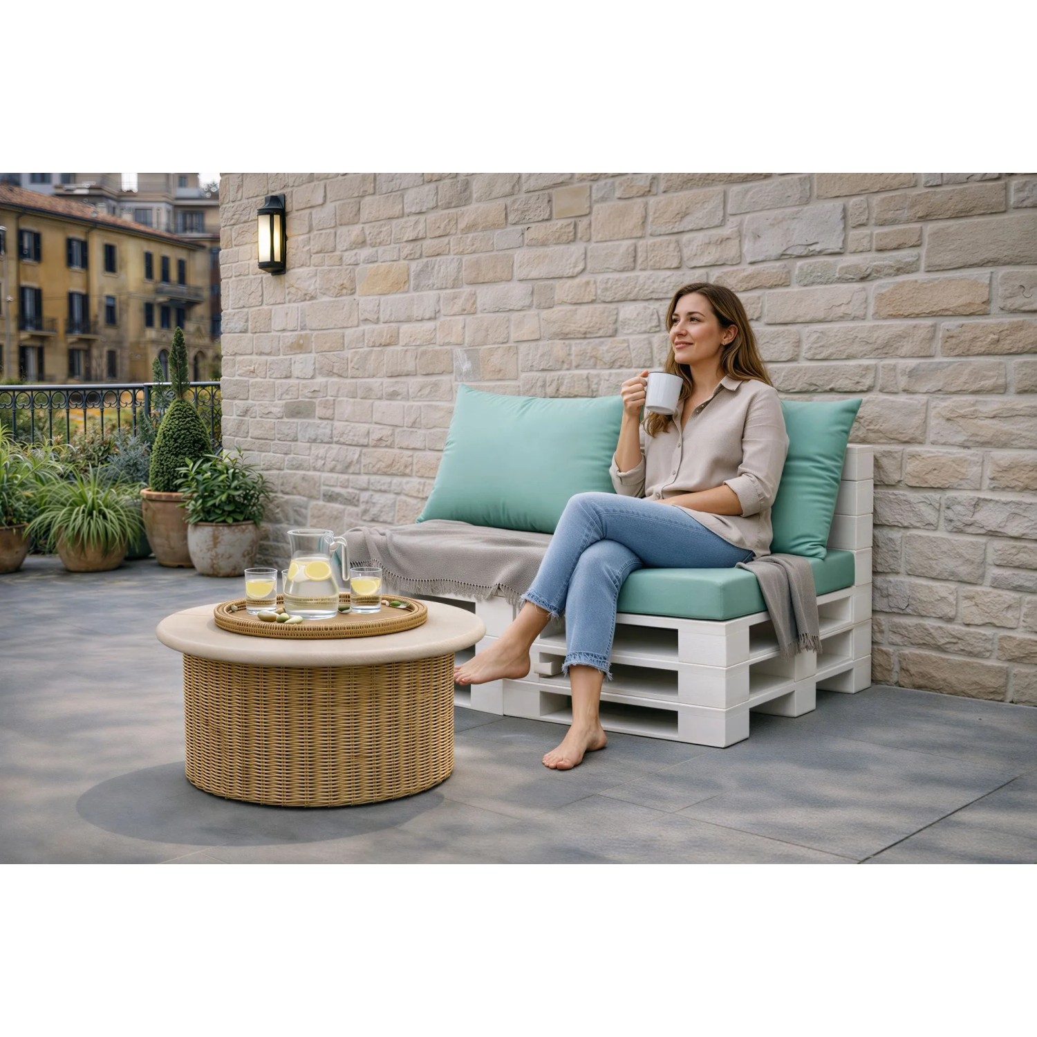 Setgarden Palettenkissen Set pastellblau auf weißem Palettensofa. Frau genießt Komfort auf Sitz- & Rückenkissen Outdoor.