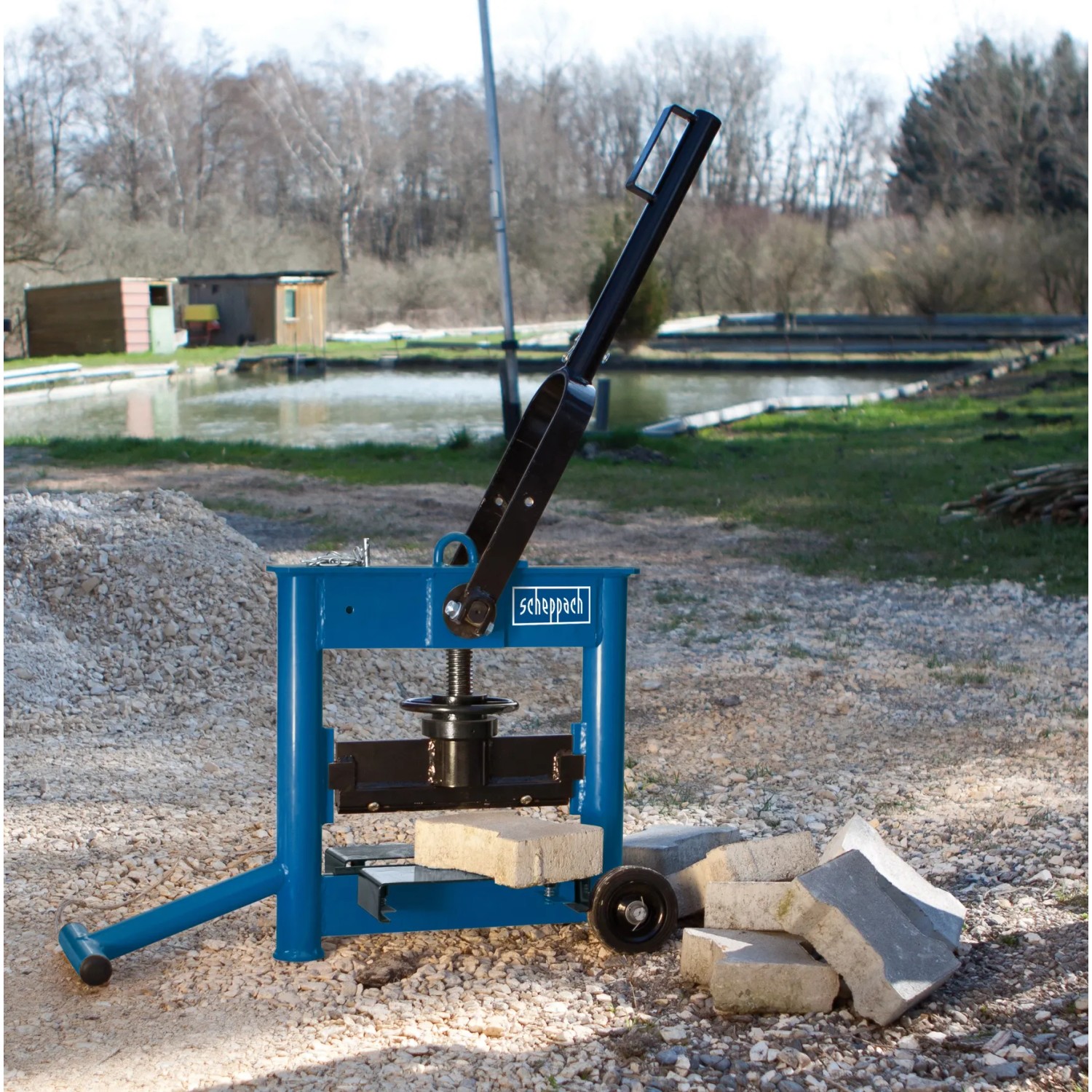 Scheppach Steintrenner HSC 130 zum Trennen von Steinen und Platten. Baumaschine mit Hebelarm und gefederten Tischauflagen.
