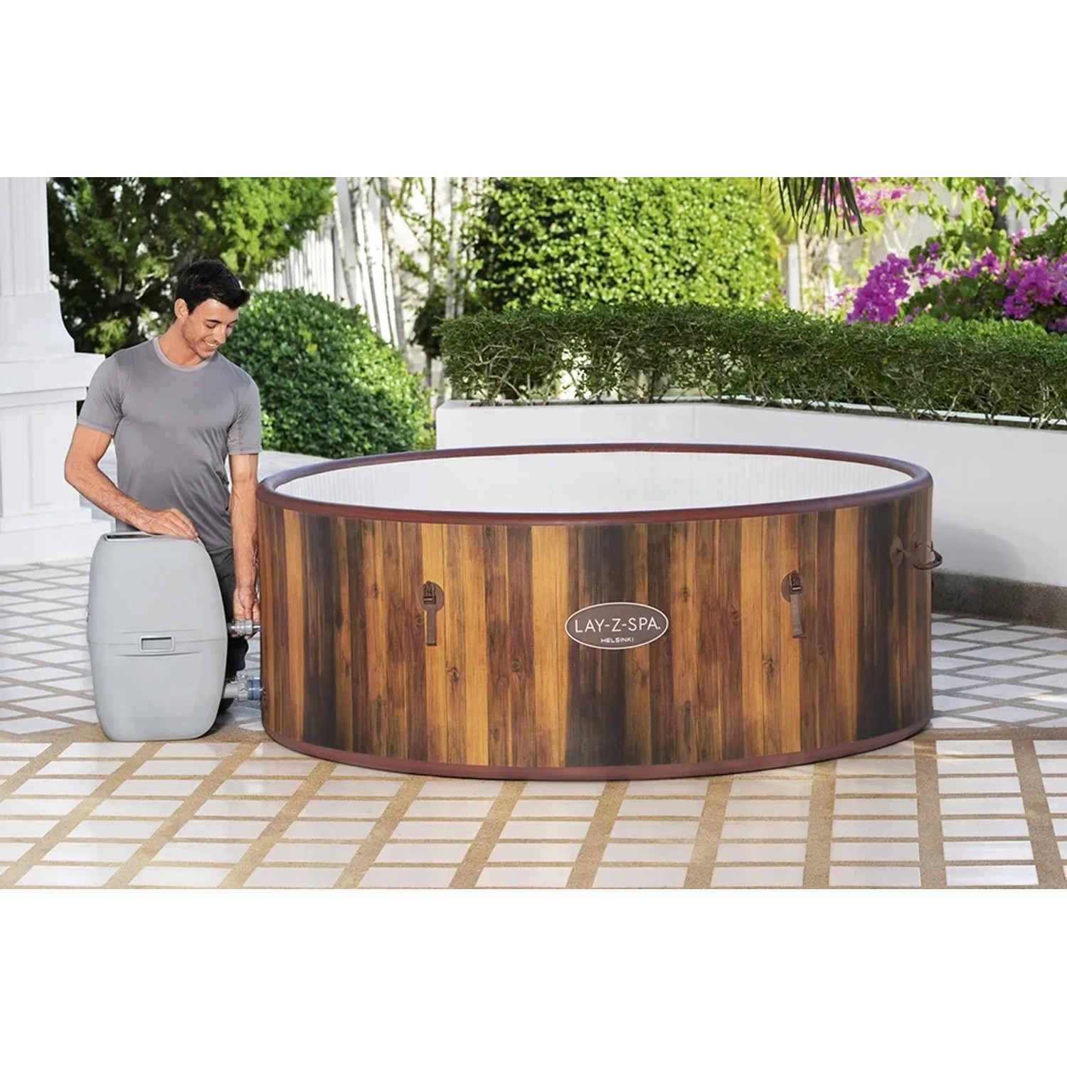 LAY-Z-SPA Helsinki AirJet Whirlpool (Ø 180cm) mit Pumpe und Mann im Garten.