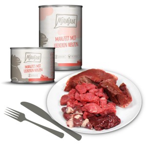 Mjamjam Katzen-Nassfutter Mahlzeit mit Herzen, Fleischstücke auf Teller, zwei Dosen im Hintergrund.