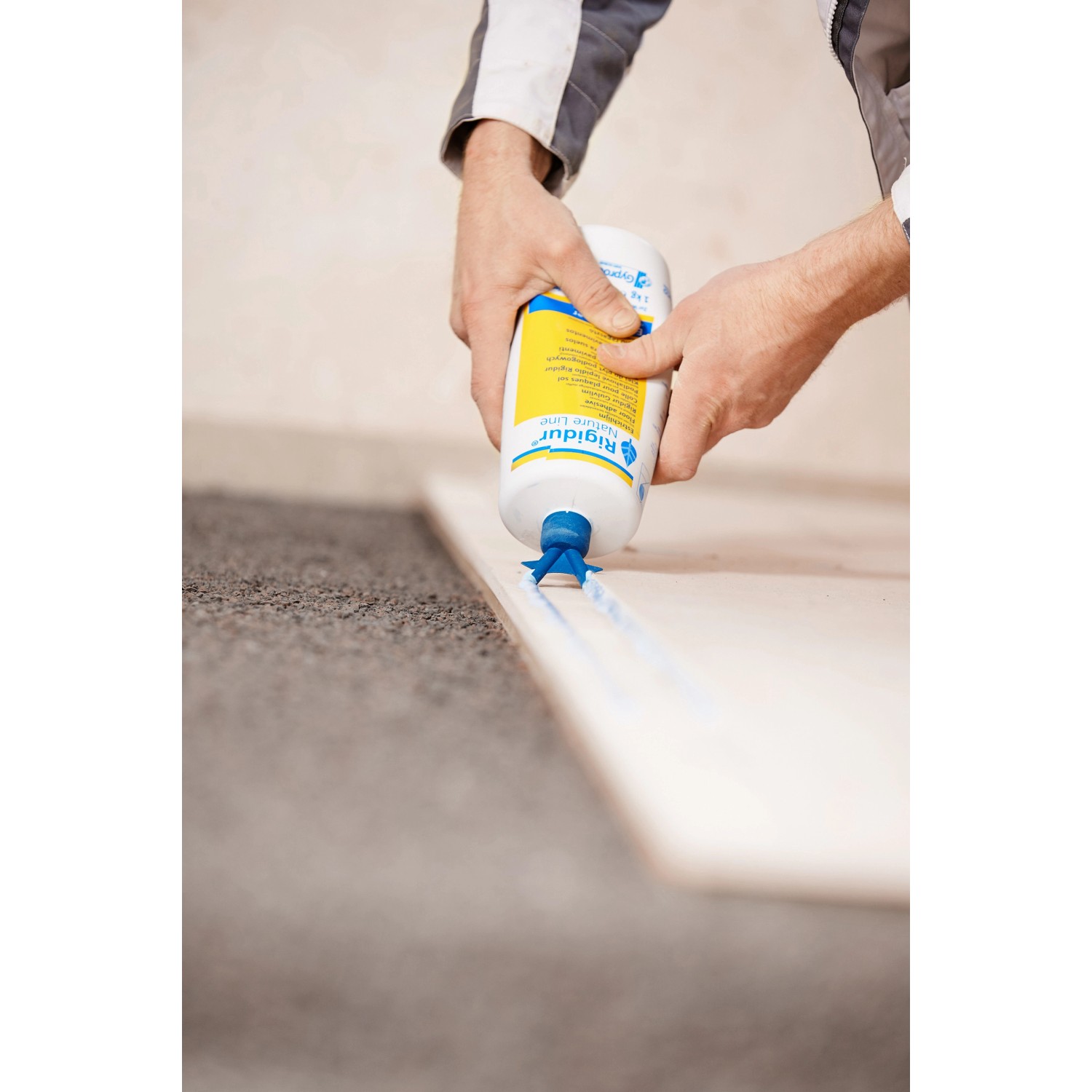 Anwendung von Rigips Rigidur Nature Line Estrichkleber (1 kg) auf einer Gipsfaserplatte.
