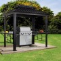 Anthrazitfarbener Sojag Grillpavillon Messina BBQ mit Grill und Ablagetischen im Garten.