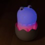 Dimmbares LED Kinder-Nachtlicht Diggy Dino RGBW im Ei, leuchtet blau und rosa.
