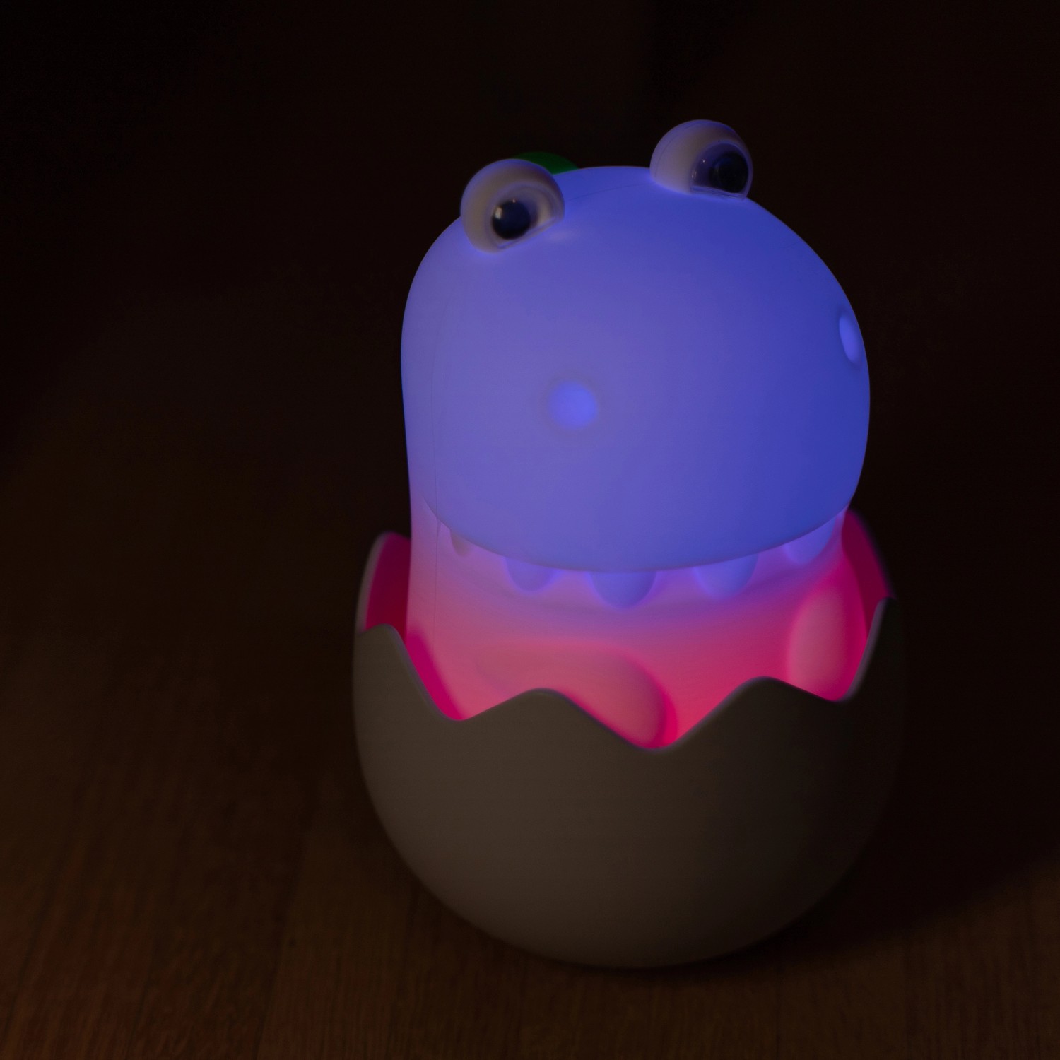 Dimmbares LED Kinder-Nachtlicht Diggy Dino RGBW im Ei, leuchtet blau und rosa.