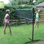 Schwarzes, verstellbares EXIT Sportnetz (155x300cm) im Garten mit spielenden Kindern.