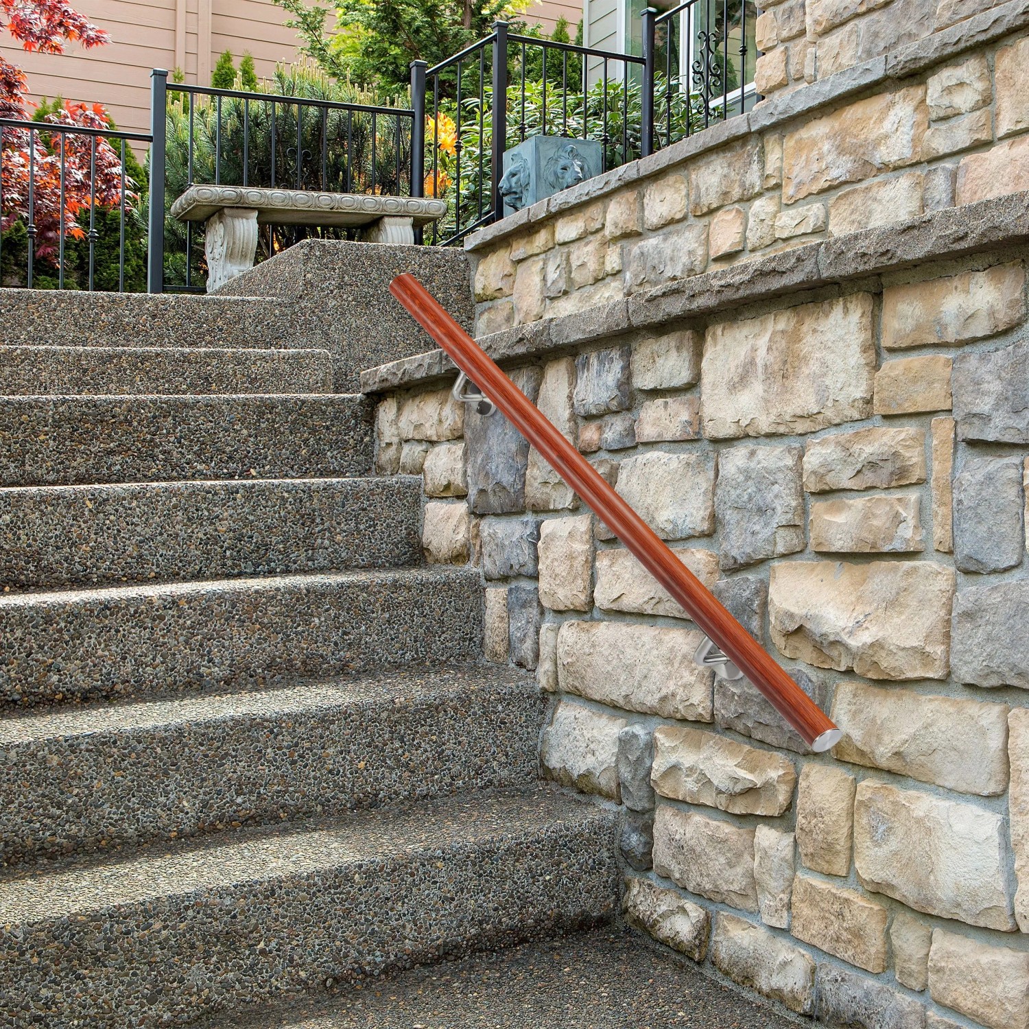 Brauner Aluminium-Handlauf in Eiche-Optik mit silbernen Edelstahl-Halterungen an Steintreppe im Außenbereich. Sicherer Halt.