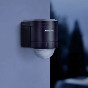 Schwarzer Steinel Bewegungsmelder IS 240 Duo mit 240° Erfassungswinkel an Wand montiert.