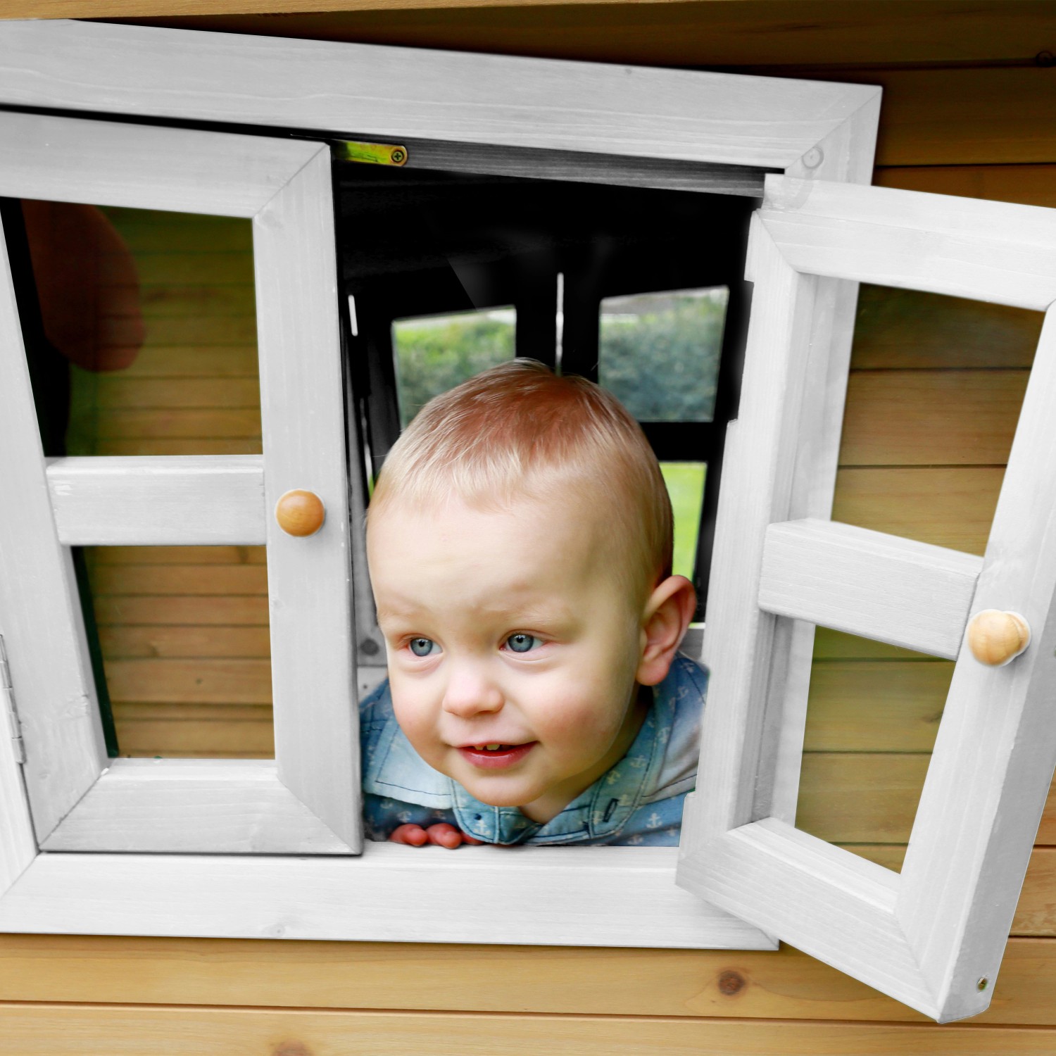 Kind schaut aus Fenster vom braun-weißen Axi Robin Spielhaus mit grauer Rutsche.