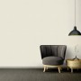 Wohnraum mit A.S. Création Vliestapete Sumatra Uni Creme, Sessel und Lampe.