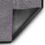 Beige-graue Karat Schmutzfangmatte Rhine 90x120cm mit aufgerollter Ecke, die die schwarze Vinyl-Rückseite zeigt.