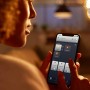 Frau steuert Philips Hue Filament Lampe per App. Vintage-Look, dimmbar, warmweiß bis kaltweiß.